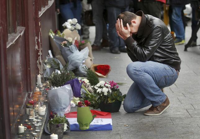 A man pays his respect outside the Le Carillon restaurant the morning after a series of deadly attacks in Paris , November 14, 2015.      REUTERS/Christian Hartmann