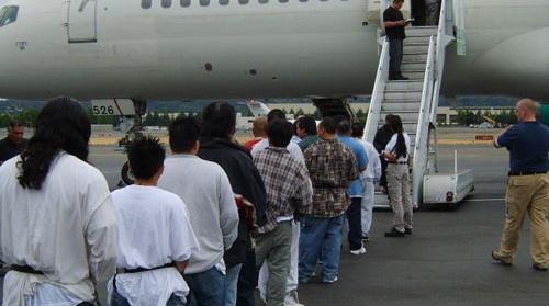 A group of immigrants getting on deportation plane going back to where they came from.