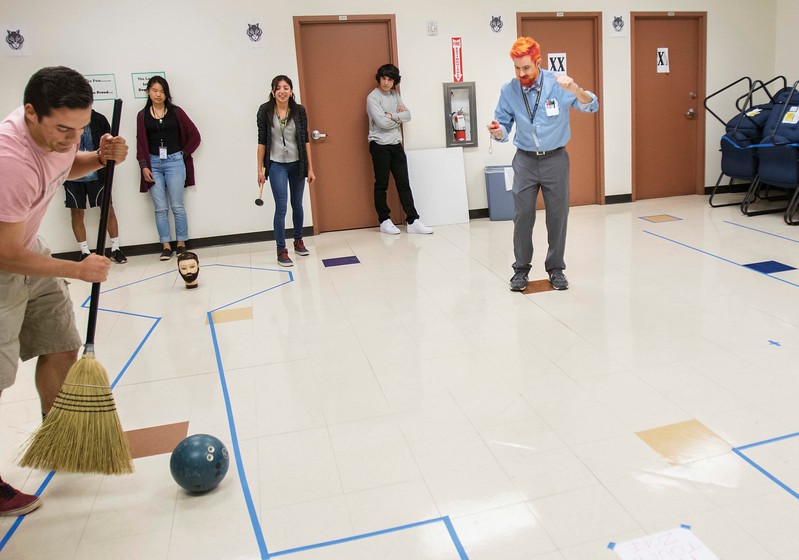 La Joya Community High School Physic Teacher Zachary Kovach watches as Senior Hunter Older works to control a bowling ball's movement through a designated obstacle course using only the force of a broom and rubber mallet, La Joya Community High School, Avondale, March 9. Kovach was recently awarded Teach of the Year by the Physics Teachers Education Coalition. Students succeeded in raising over $600 for a leukemia fundraiser, which resulted in Kovach permenently coloring his hair in shocking, vibrant colors. To see all photos from this shoot, go to www.westvalleyview.com/pictures.  View photo by Jordan Christopher