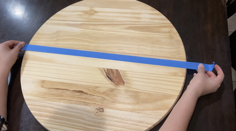 Putting tape on Round Wood Sign