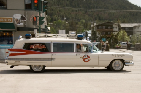 Ghostbusters car that is a white car with red detail that has a ghost with a red x over it.