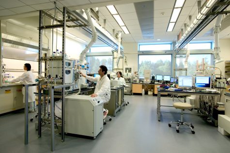 Three health workers working in a lab with machines