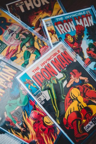 Image is a stack of Marvel comics, such as Iron Man and Thor.