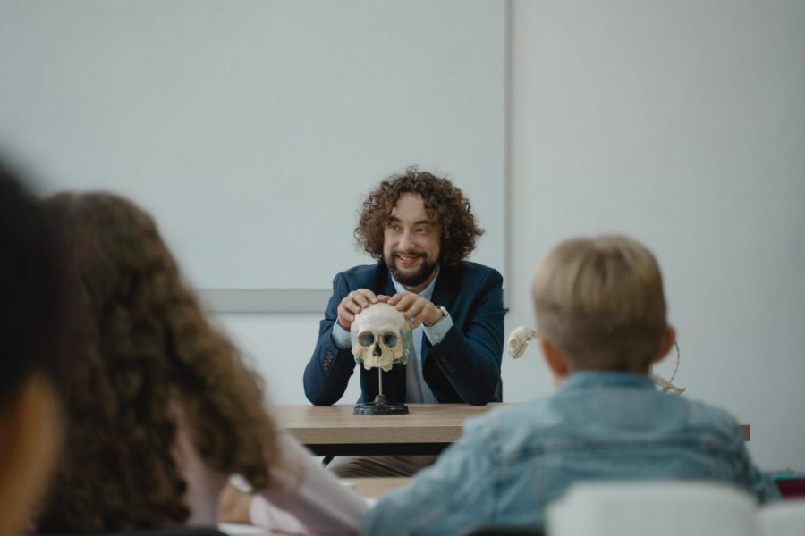 In this picture it shows a teacher teaching his students about the human skull.