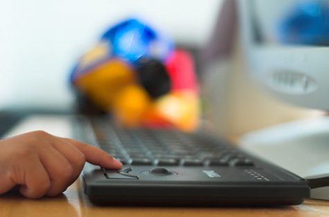 Person touching computer keyboard with index finger