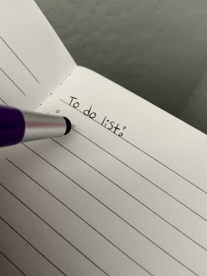 A pen meeting a piece of paper with the words "to do list" written at the top.