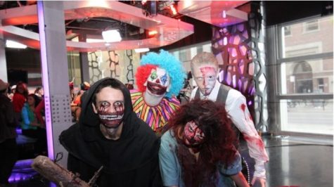 Four people dressed in Halloween costumes staring at the camera trying to look scary