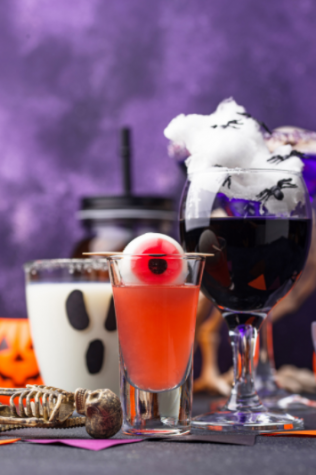 Eyeball in a glass of an unknown orange liquid with more glasses behind it with a purple background