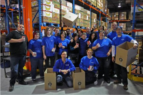 A big group of people at a food bank, holding boxes