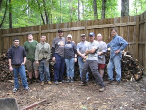 People standing in front of a big fence