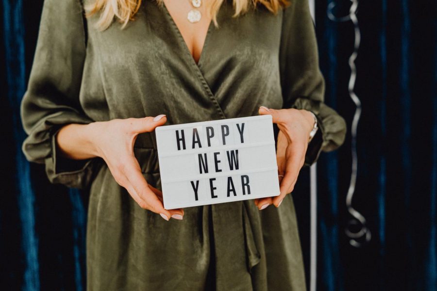 Woman holding small white sign reading Happy News Years