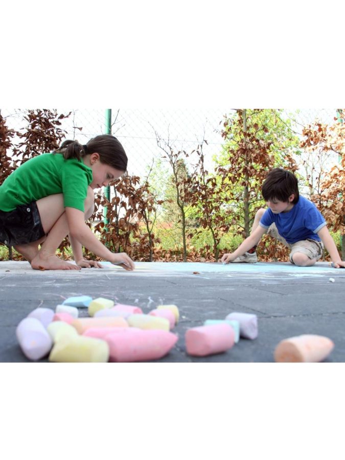 Children+using+colorful+chalk+to+draw+different+creative+images+on+the+sidewalk.