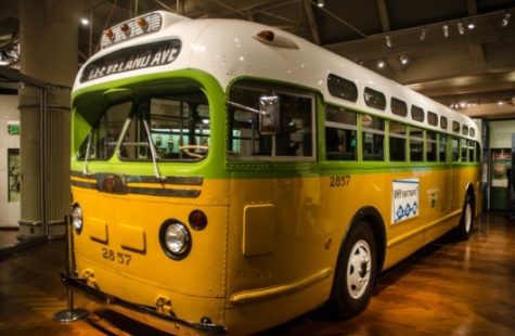 A bus inside a museum, Colors from top to bottom are whit, green, and yellow